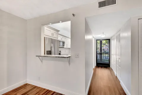 a view of a hallway with wooden floor and staircase