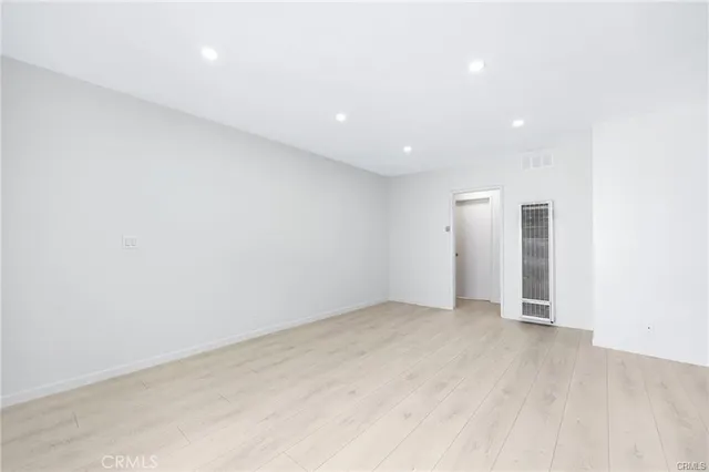 an empty room with wooden floor and closet