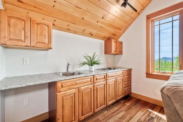 a kitchen with stainless steel appliances granite countertop a sink a cabinets and wooden floor