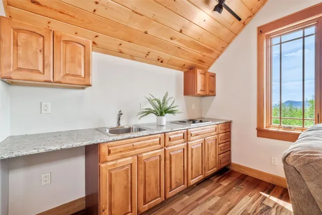 a kitchen with stainless steel appliances granite countertop a sink a cabinets and wooden floor