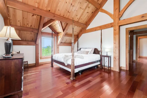 a white bed sitting in a room next to a window