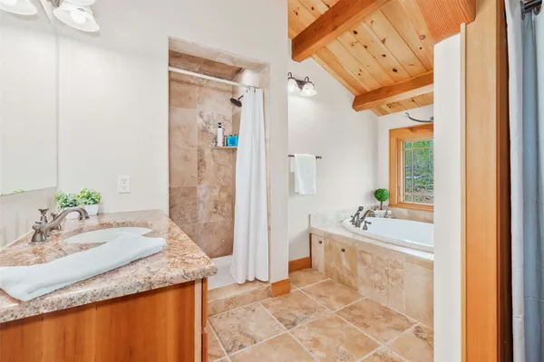 a bathroom with a granite countertop sink and a mirror