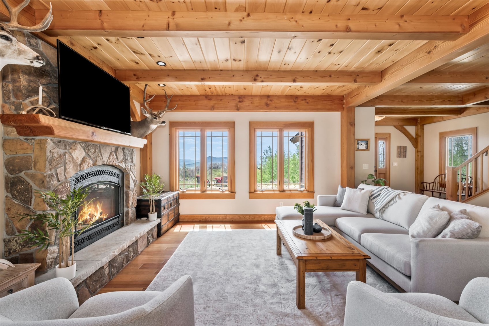 51193 Smith Creek Road Steamboat Springs, CO 80487 - Photo 9 of 48 a living room with furniture a fireplace and a flat screen tv