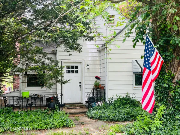 a view of house with a yard and sitting area