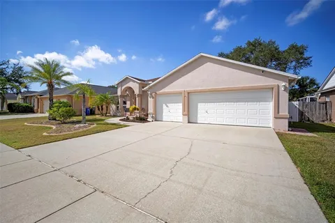 a view of a white house with a yard and potted plants