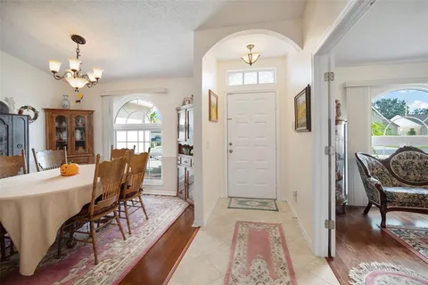 a view of a dining room with furniture a chandelier and wooden floor