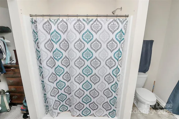 a bathroom with a toilet and a shower curtain