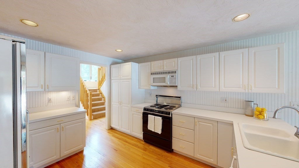 90 Cranberry Circle Sudbury, MA 01776 - Photo 13 of 37 a kitchen with white cabinets and appliances