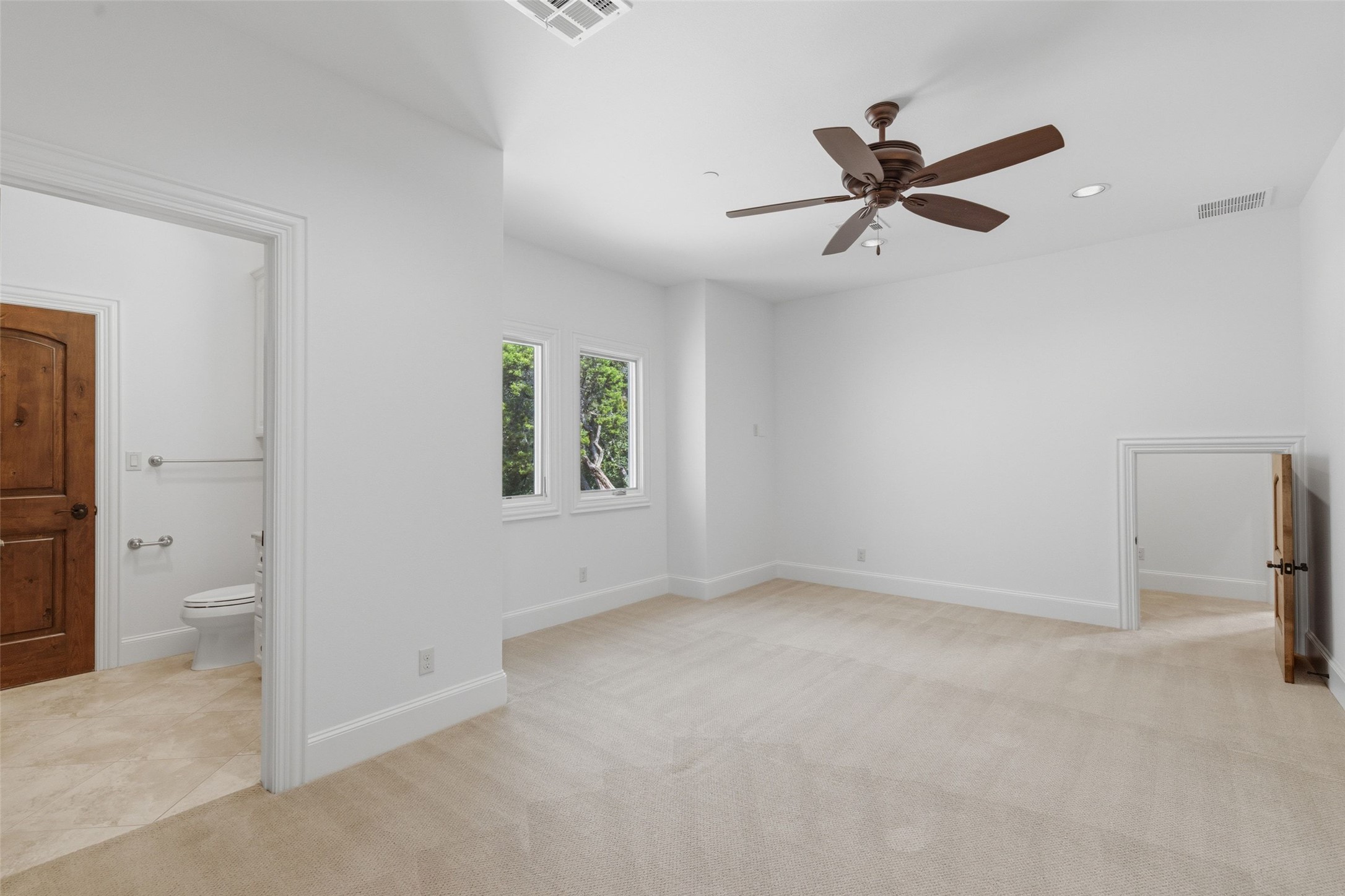1414 The High Road Austin, TX 78746 - Photo 26 of 40 An airy bedroom with a ceiling fan offers a seamless transition to the adjoining private bath.