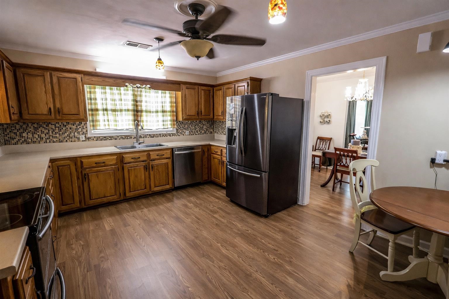 7840 Munford Giltedge Road Burlison, TN 38015 - Photo 12 of 38 a kitchen with stainless steel appliances granite countertop a refrigerator a sink dishwasher a stove and a dining table with wooden floor