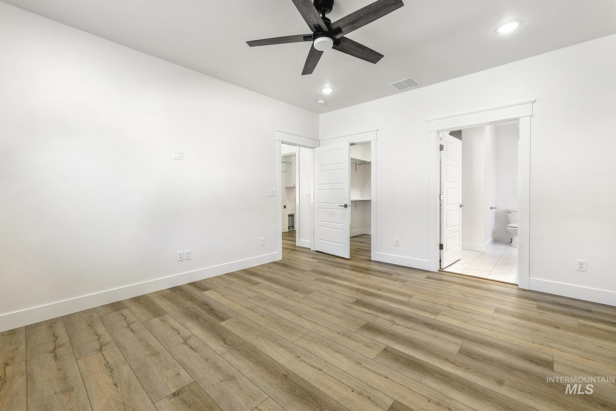 1428 Haizlee Way Twin Falls, ID 83301 - Photo 14 of 23 Unfurnished bedroom with a walk in closet, a ceiling fan, light wood-type flooring, ensuite bathroom, and recessed lighting