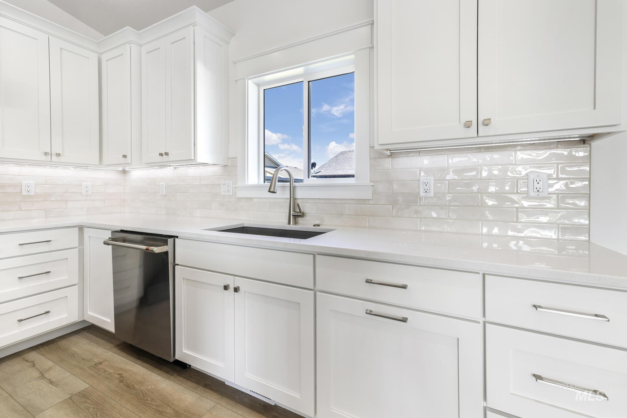1428 Haizlee Way Twin Falls, ID 83301 - Photo 4 of 23 Kitchen with white cabinets, light stone countertops, and stainless steel dishwasher