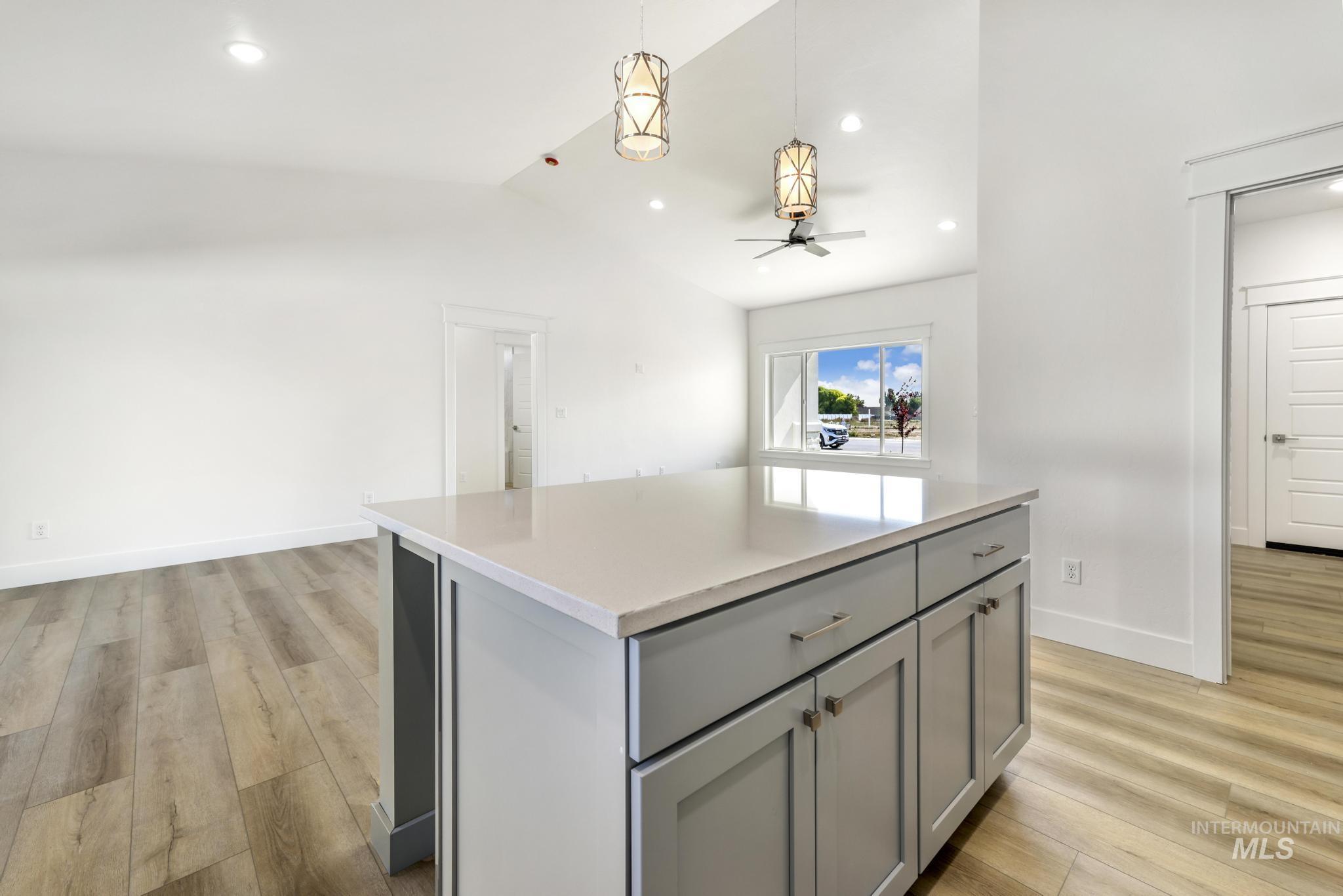 1428 Haizlee Way Twin Falls, ID 83301 - Photo 6 of 23 Kitchen featuring a center island, gray cabinetry, light wood finished floors, pendant lighting, and lofted ceiling