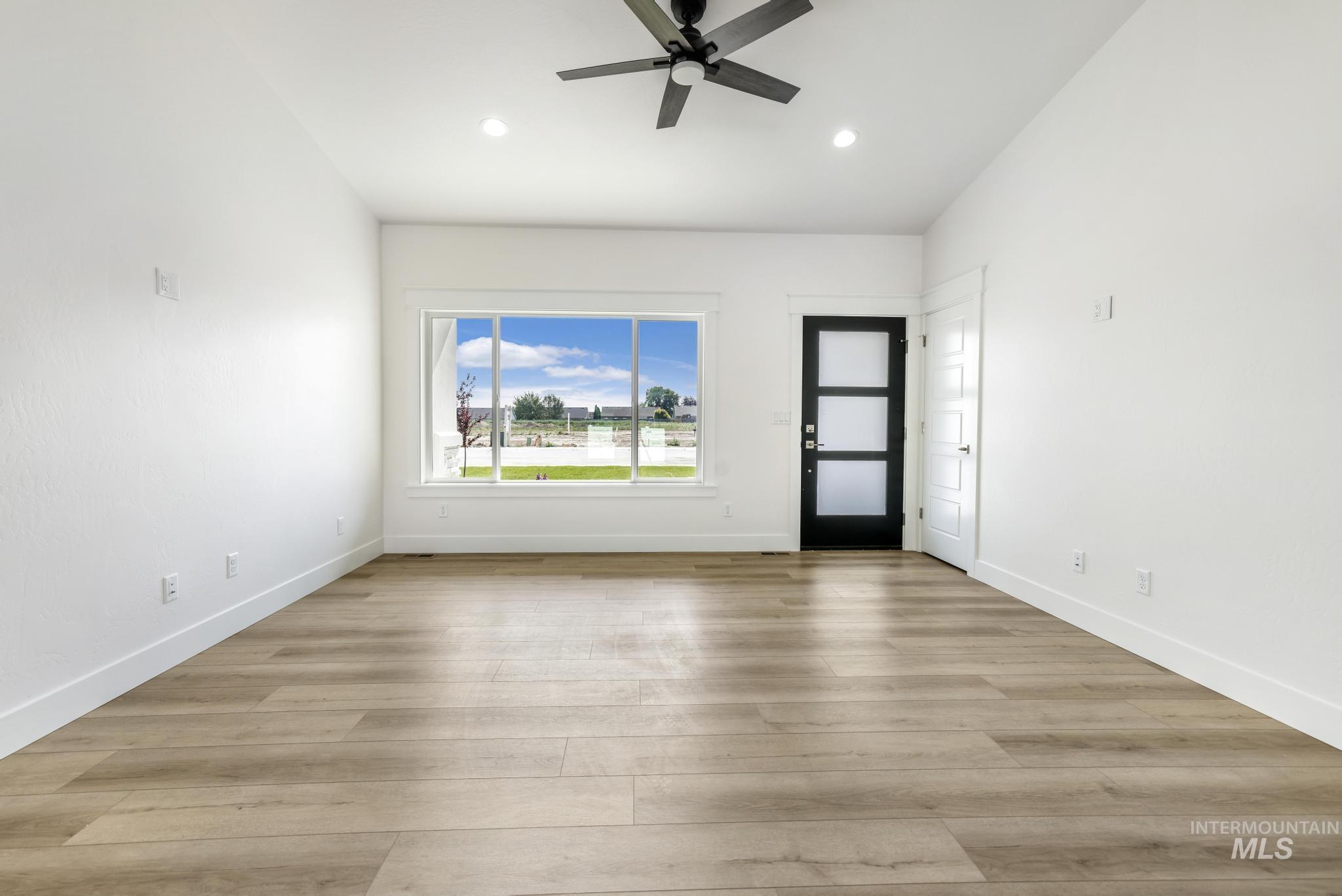 1428 Haizlee Way Twin Falls, ID 83301 - Photo 8 of 23 Empty room with ceiling fan, vaulted ceiling, light wood-type flooring, and recessed lighting