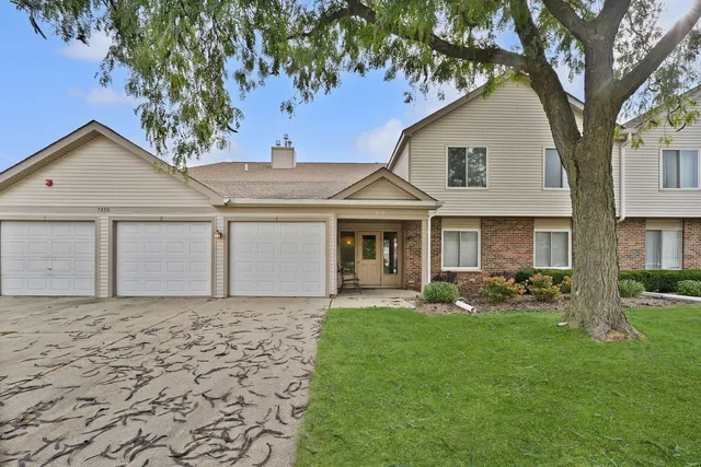 a front view of a house with a yard and trees