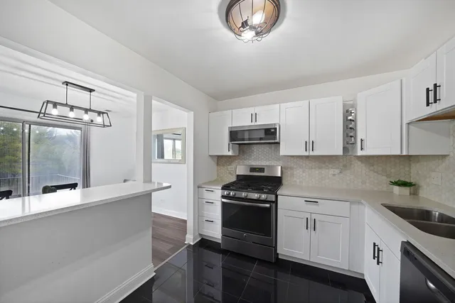 a kitchen with stainless steel appliances a stove a sink and cabinets