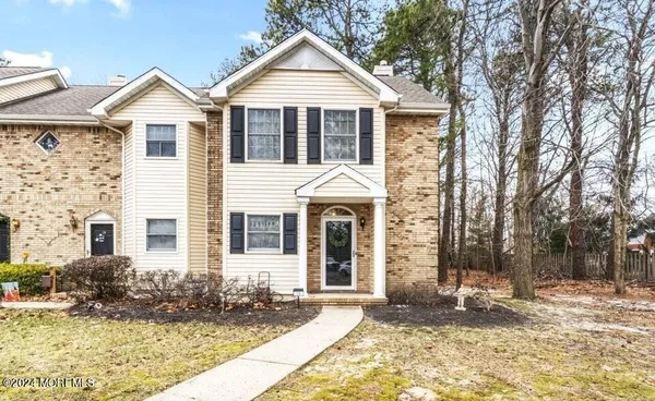 a front view of a house with a yard and trees