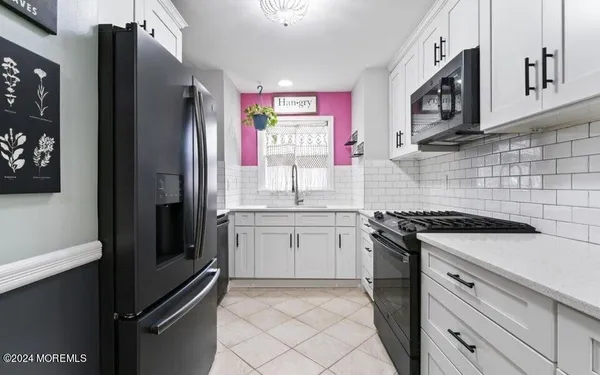 a kitchen with granite countertop a refrigerator stove and sink