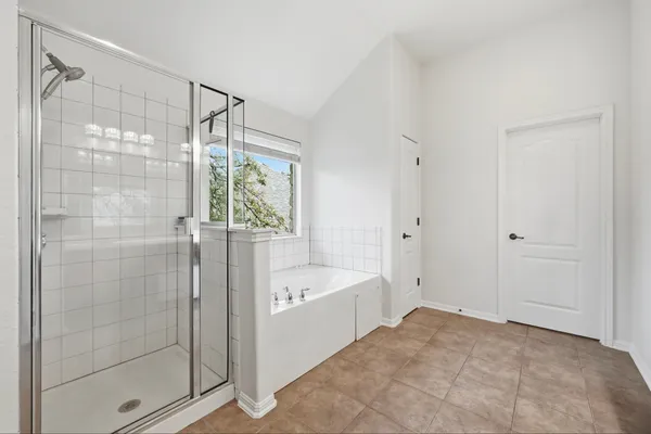 a spacious bedroom with a bed and a window