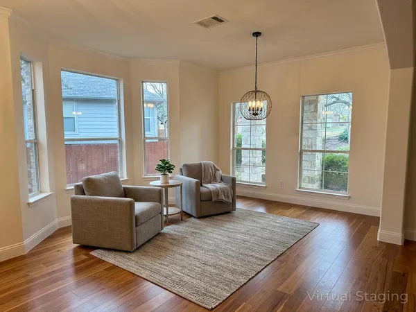 a view of a room with wooden floor and furniture