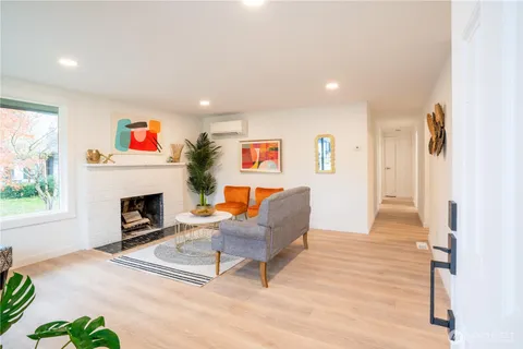 a living room with furniture a fireplace and a large window
