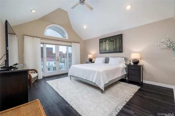 a spacious bedroom with a bed and wooden floor