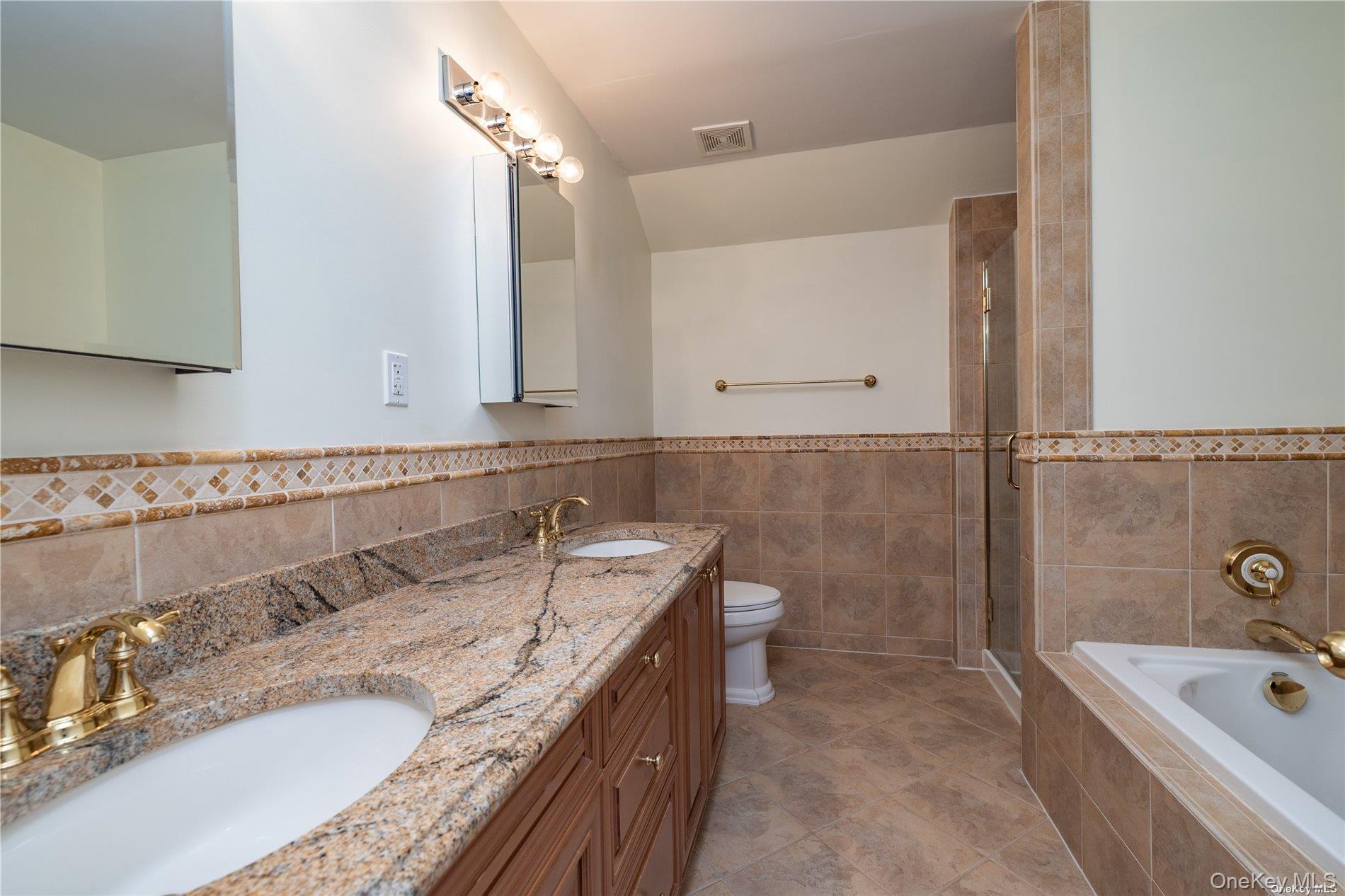 159 Monroe Boulevard, Unit UPPR Long Beach, NY 11561 - Photo 18 of 24 a bathroom with a granite countertop bathtub a sink and a mirror