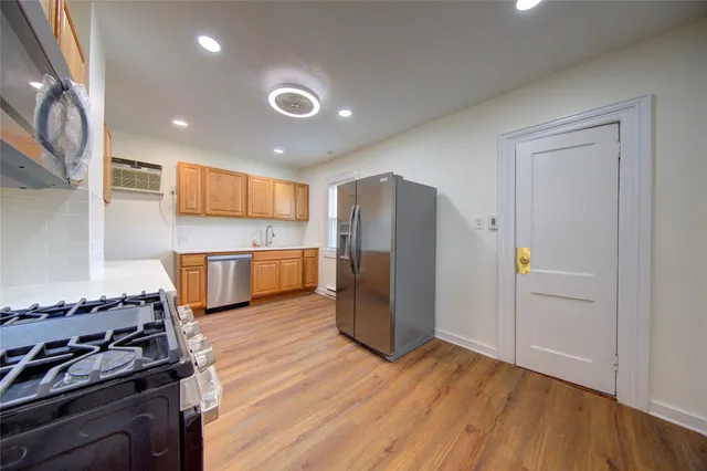 a kitchen with stainless steel appliances granite countertop a refrigerator and a stove top oven