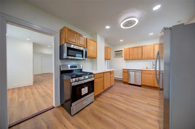a kitchen with stainless steel appliances granite countertop a stove a sink and a microwave