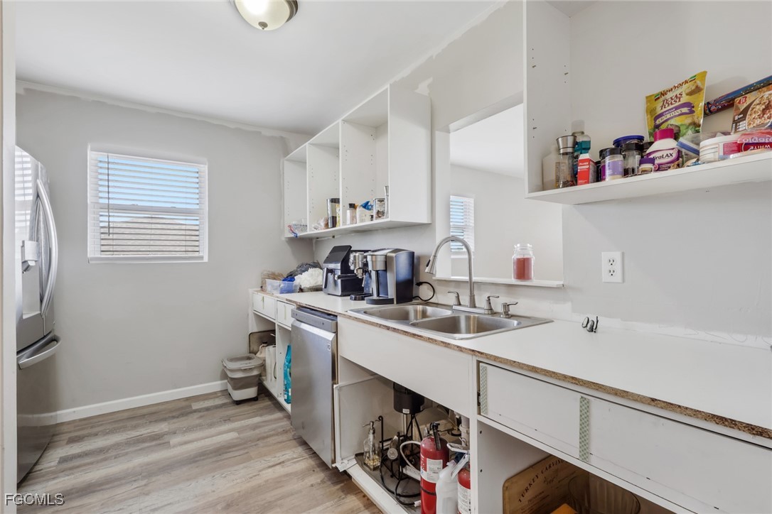 1506 Rena Avenue South Lehigh Acres, FL 33976 - Photo 11 of 39 a kitchen with a sink cabinets and wooden floor