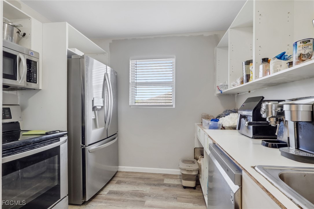 1506 Rena Avenue South Lehigh Acres, FL 33976 - Photo 12 of 39 a kitchen with a sink appliances and cabinets