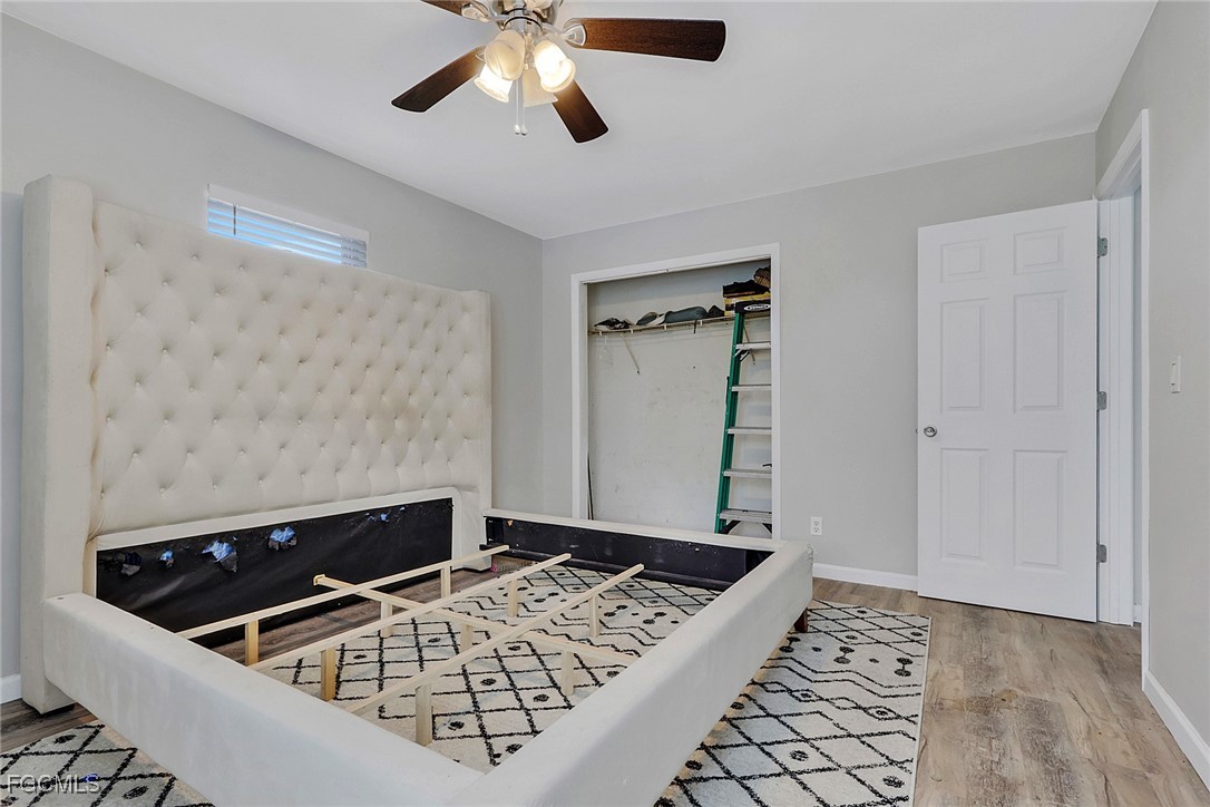 1506 Rena Avenue South Lehigh Acres, FL 33976 - Photo 21 of 39 a view of a livingroom with wooden floor and a ceiling fan