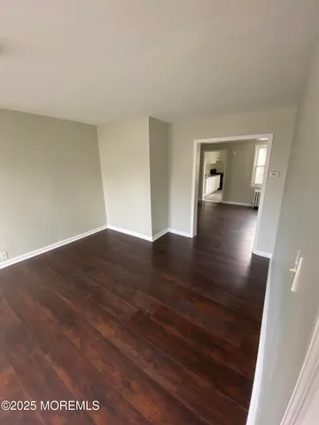 a view of a room with wooden floor and a window