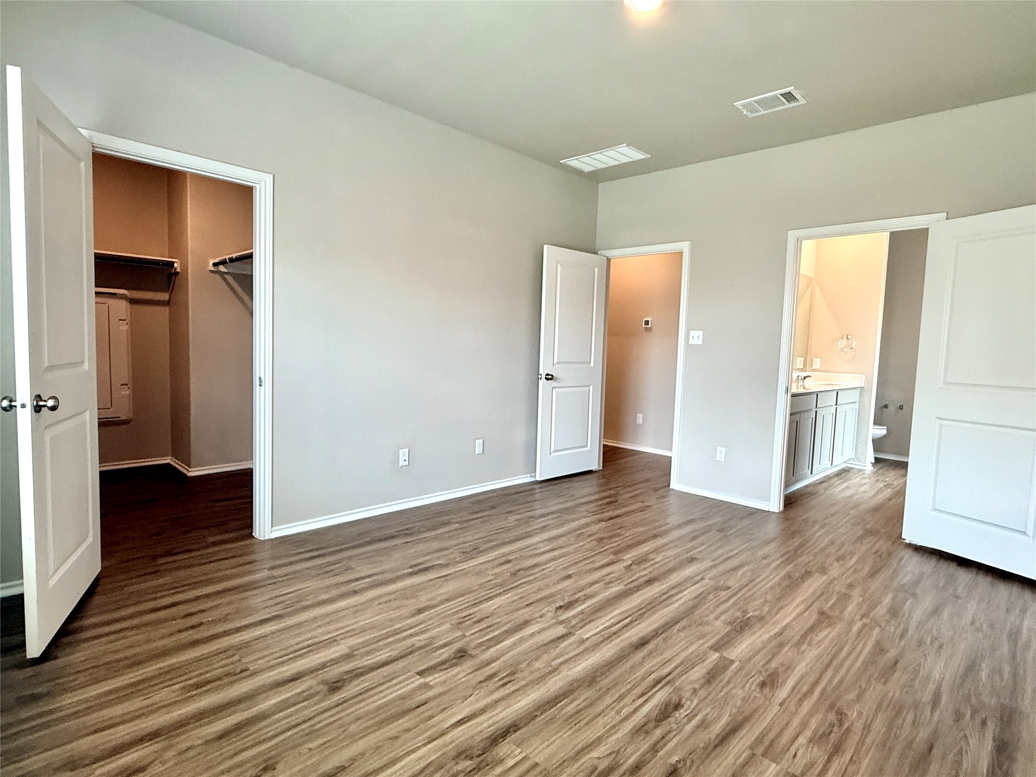 129 Perfect World Loop Jarrell, TX 76537 - Photo 14 of 31 An inviting primary bedroom with warm flooring provides access to a private bathroom and generous walk-in closet.