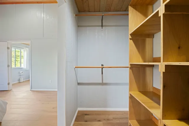 a view of walk in closet with empty racks