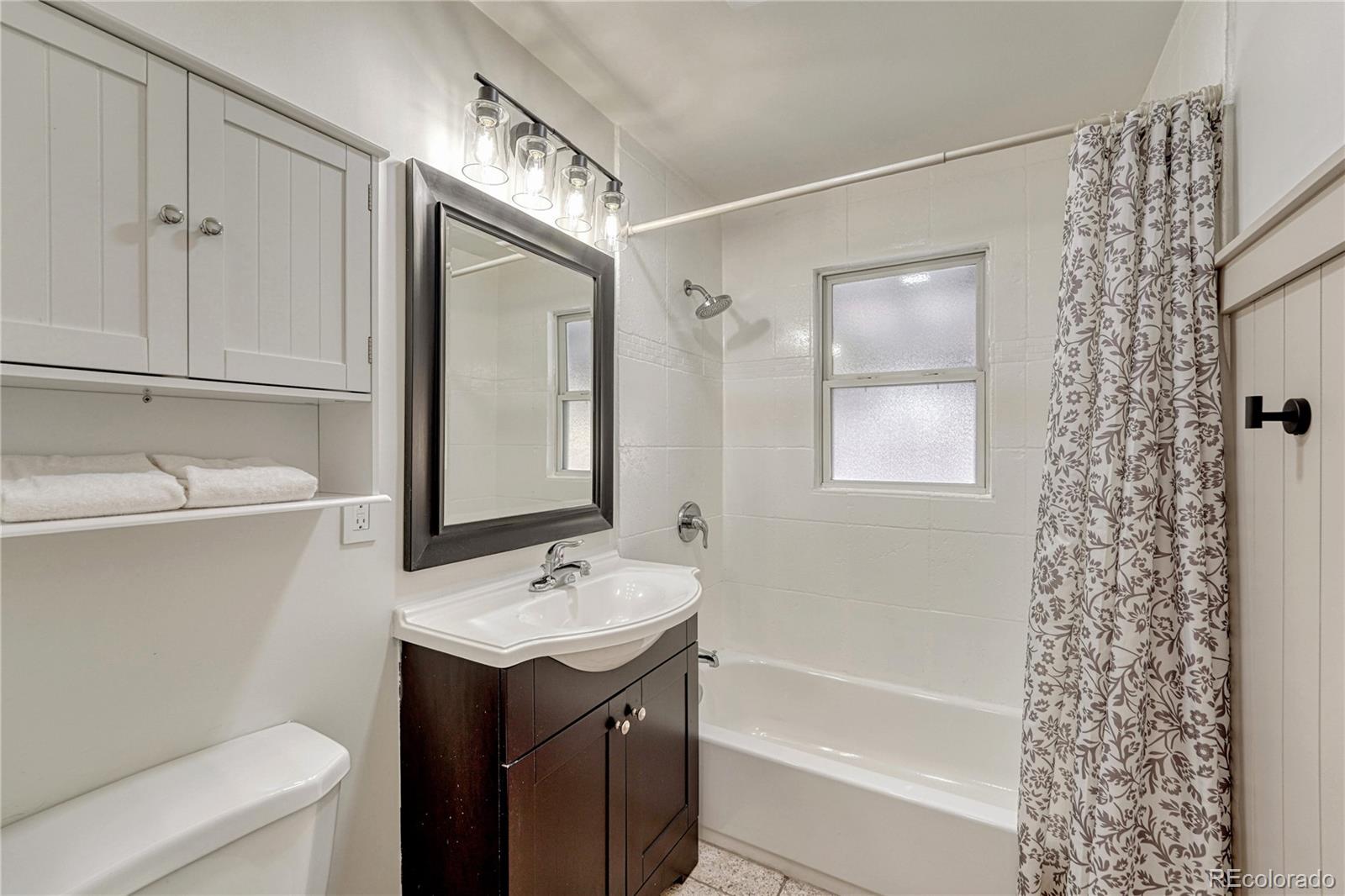 1111 South Perry Street Denver, CO 80219 - Photo 9 of 23 a bathroom with a sink a toilet and shower