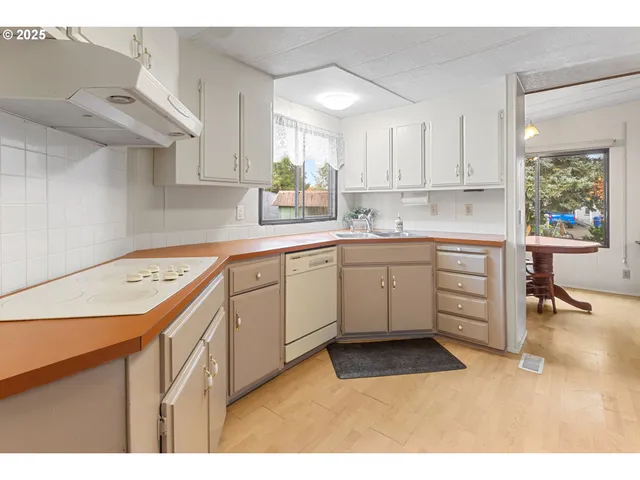 a kitchen with a sink a window and cabinets