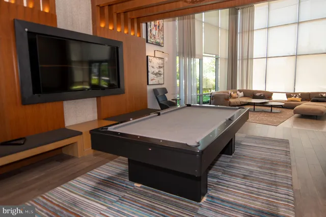 a living room with a bed furniture and a flat screen tv