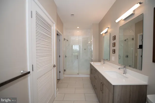 a bathroom with a double vanity sink mirror and shower