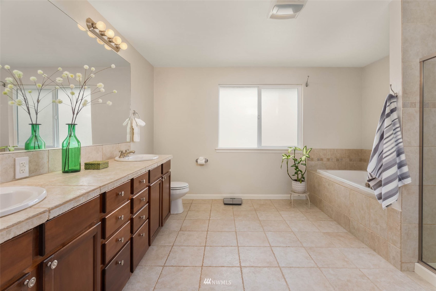 314 171st Street Southeast Bothell, WA 98012 - Photo 18 of 36 a spacious bathroom with a double vanity sink a mirror and a bathtub