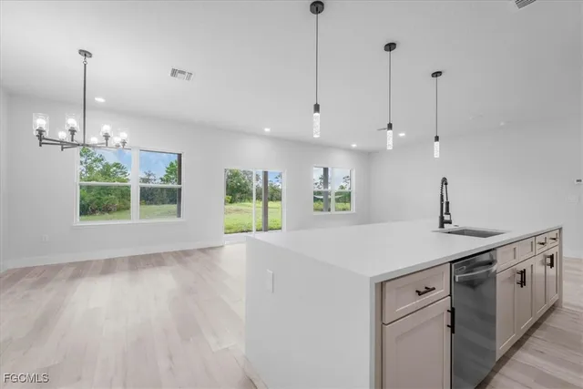 a kitchen with a stove a sink a window and wooden floor