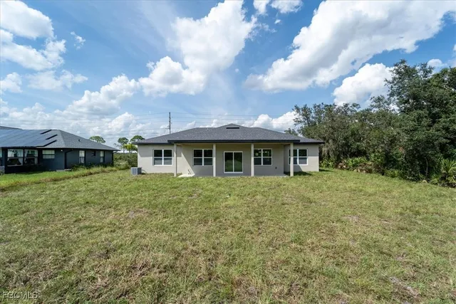 an aerial view of residential houses with outdoor space and trees