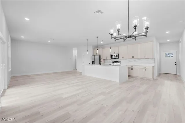 a large kitchen with kitchen island a stove a sink a center island and wooden floor