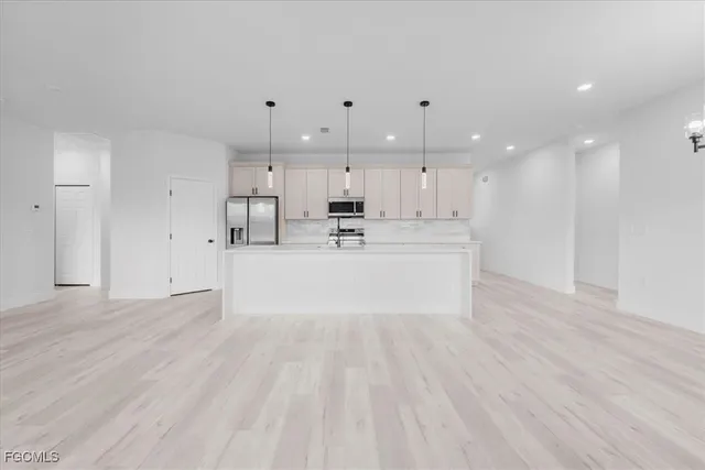 a view of kitchen with kitchen island a sink wooden floor and a counter top space
