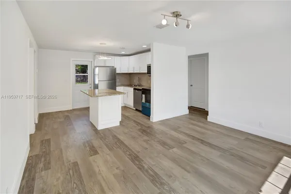 a view of a kitchen with a sink and dishwasher a refrigerator with wooden floor