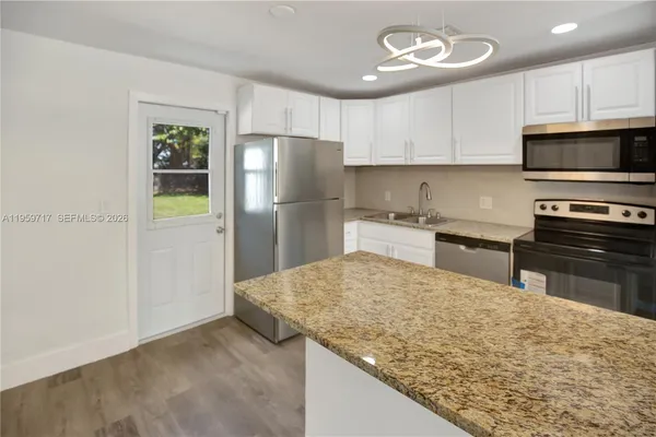 a kitchen with stainless steel appliances granite countertop a refrigerator sink and microwave