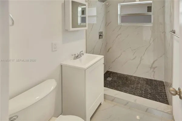 a bathroom with a sink a toilet and shower
