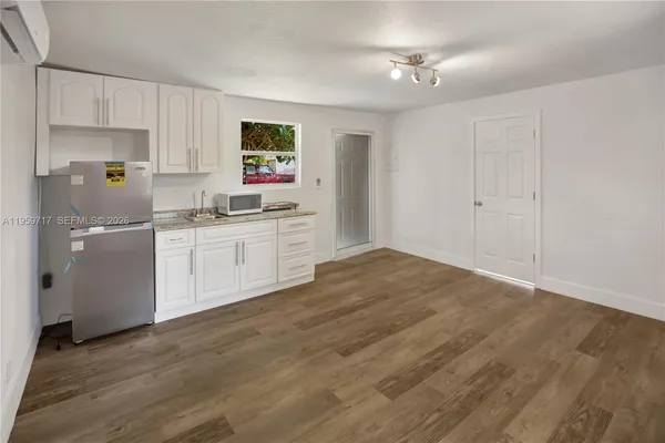 a kitchen with a sink cabinets and wooden floor