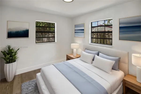 a bedroom with a bed a couch and potted plant