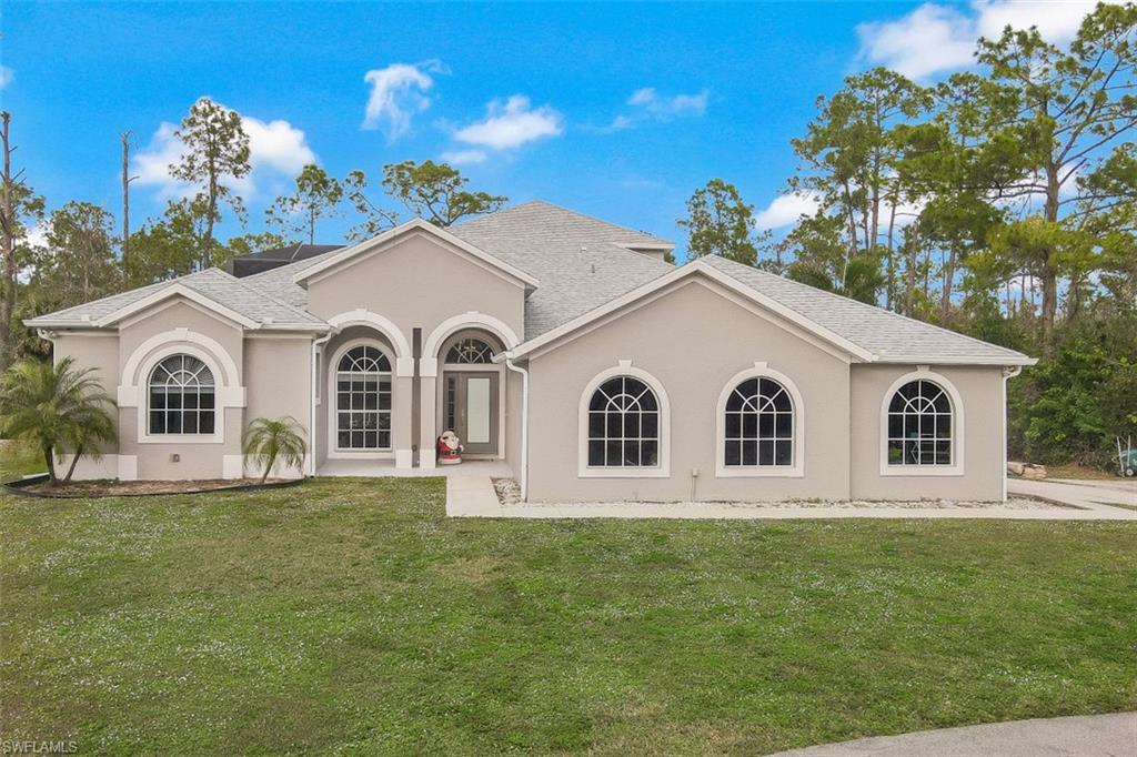 a view of a white house with a yard and plants